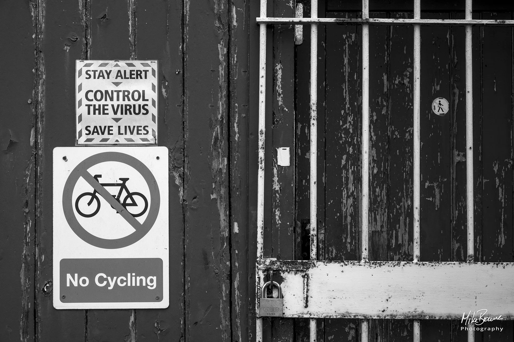 Signs saying Control the virus and stop cycling on a peeling wooden wall