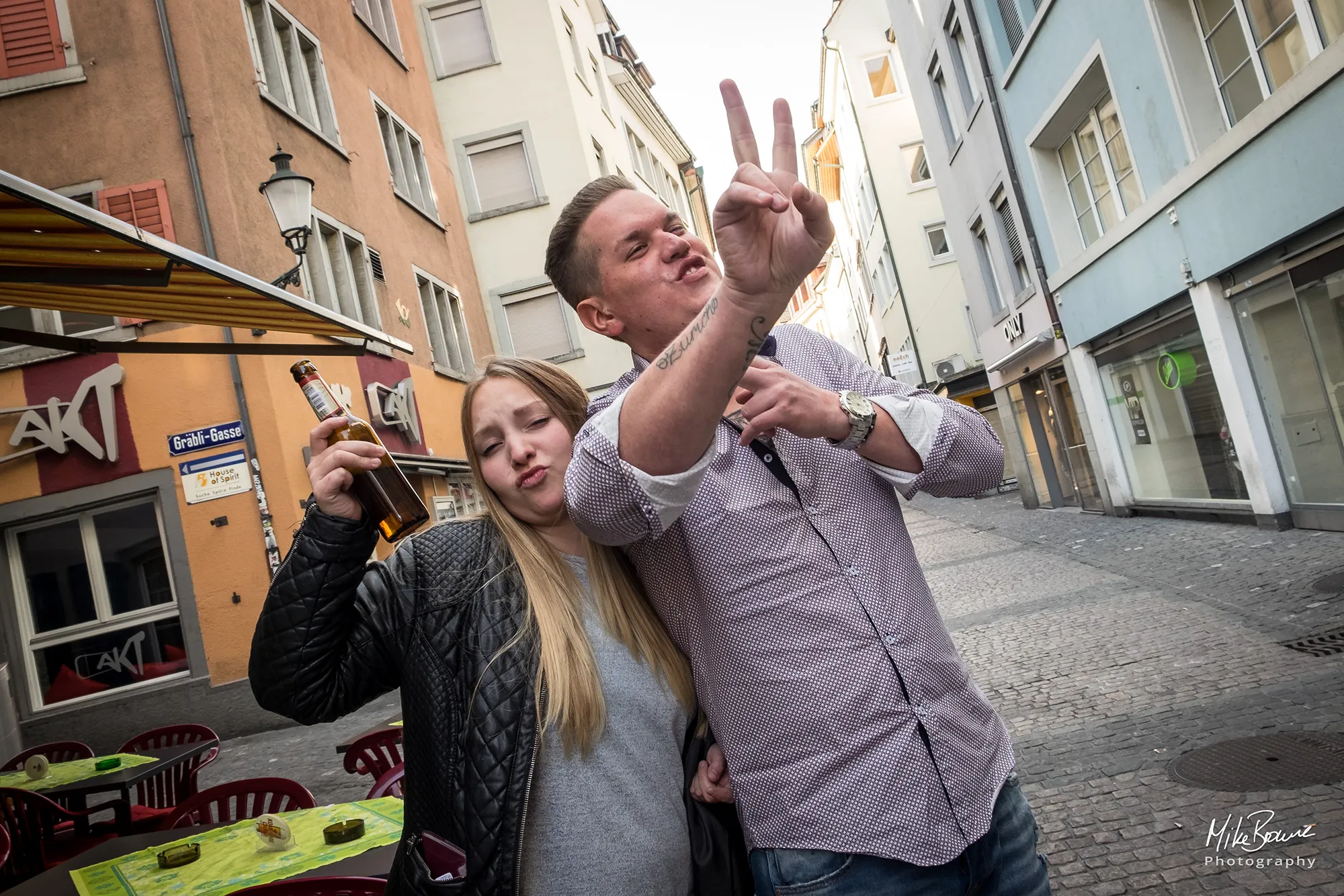 Young woman and man party goers raising a bottle in Zurich