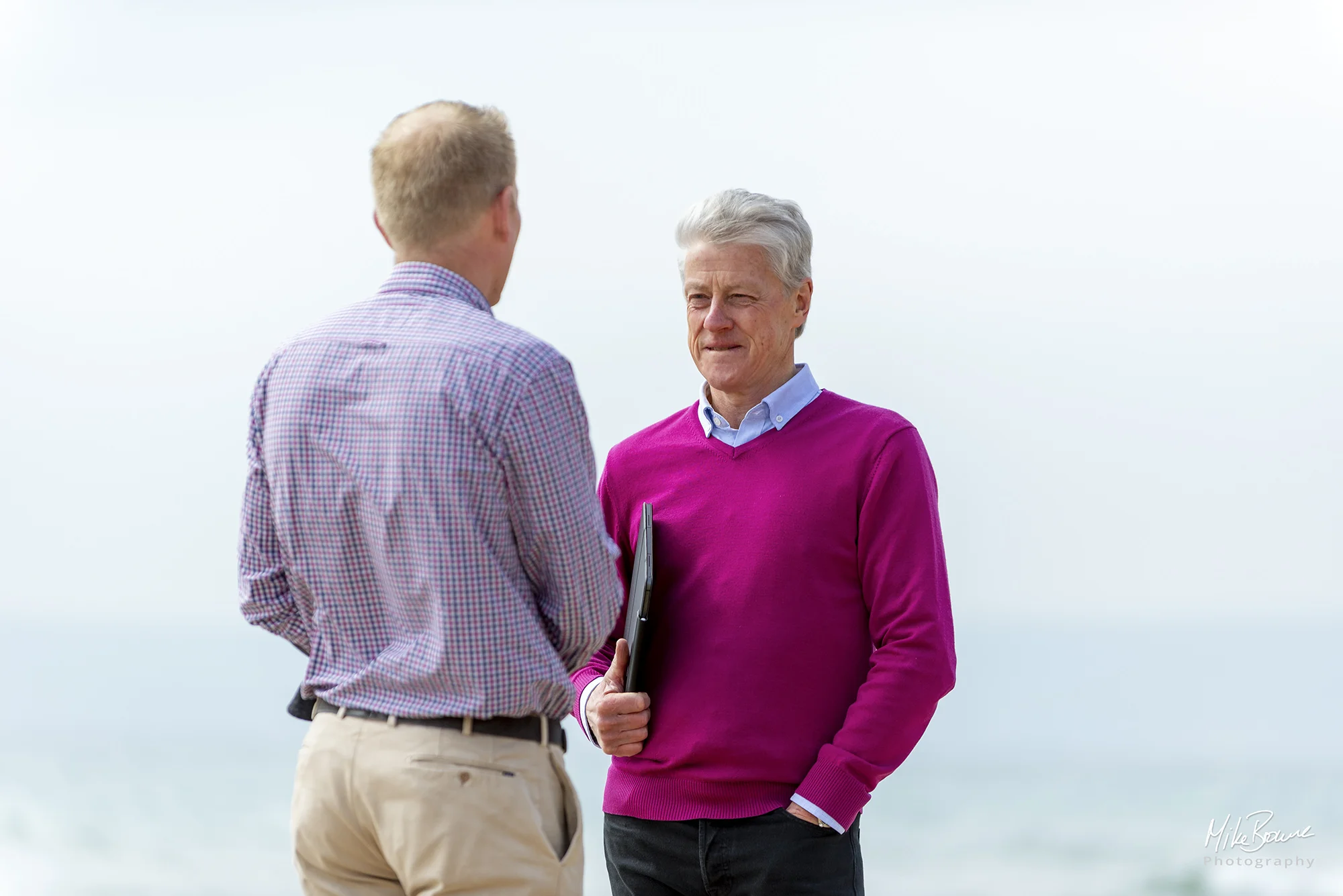 Two businessmen in conversation by the sea
