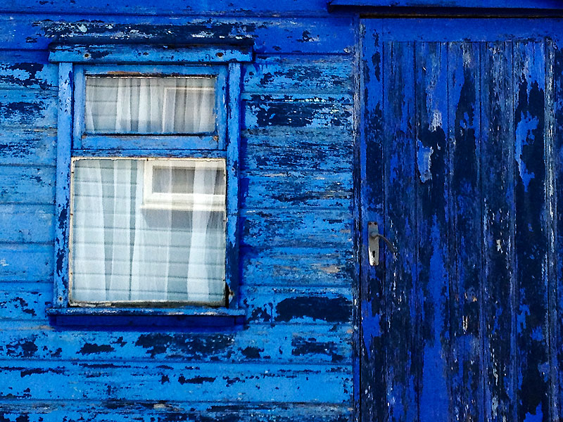 Window frame of weathered blue beach hut