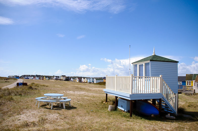 Separate beach hut with table chair and raised porch area on the grass