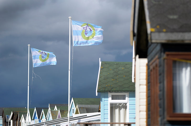Two flags blowing marking the Beach House at Mudeford