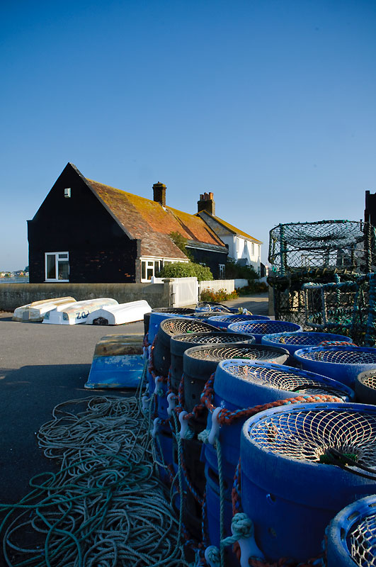 Fishing pots stacked up in front of house in Mudeford conservation area