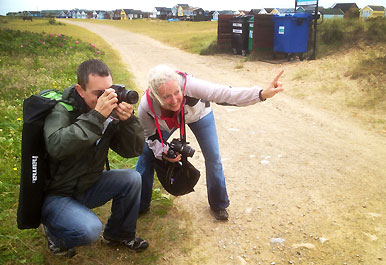 Two workshop attendees crouching on the path with cameras in hand