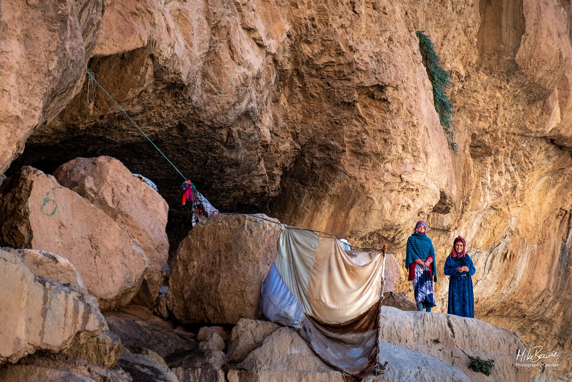 Mother and daughter standing outside their cave home in Todra Gorge, Morocco