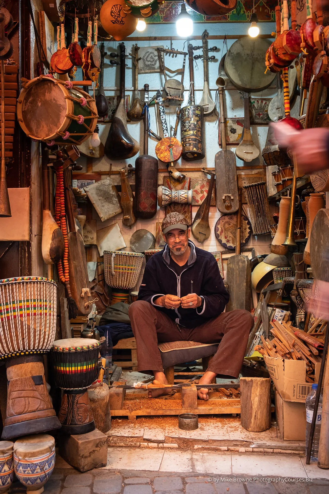 Smiling wood carver surrounded by his work in a back street of Marrakech, Morocco