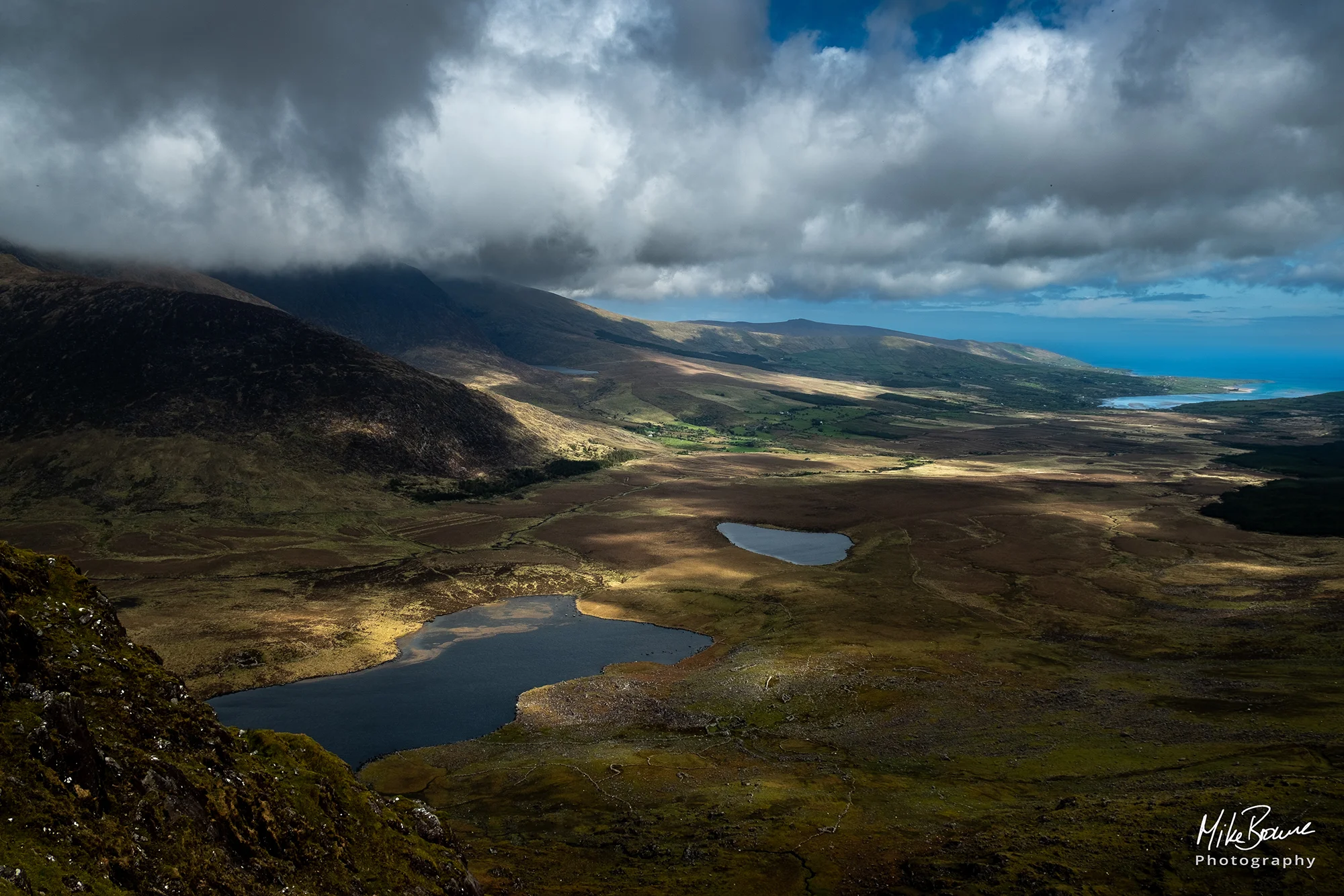 Pools of light shining through clouds on a valley floor on Dingle peninsular in Ireland