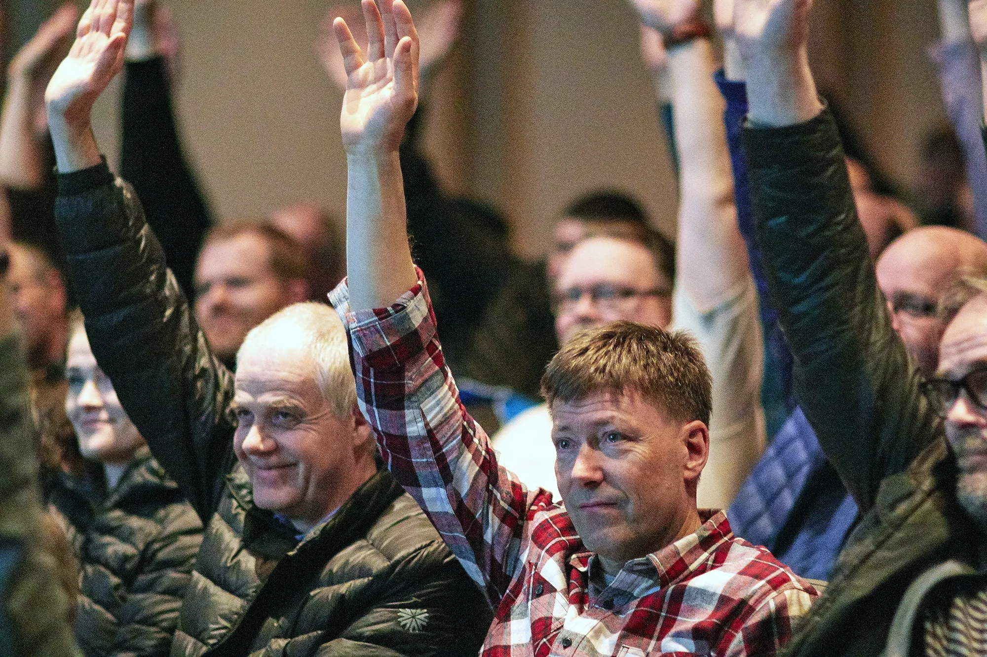 Older white males with one hand in the air