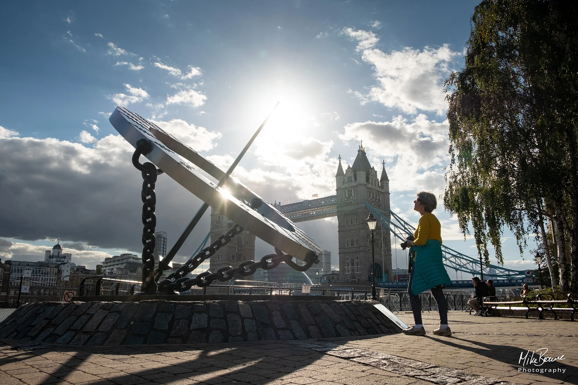 The Timepiece Sundial sculpture at the foot of Tower Bridge with woman