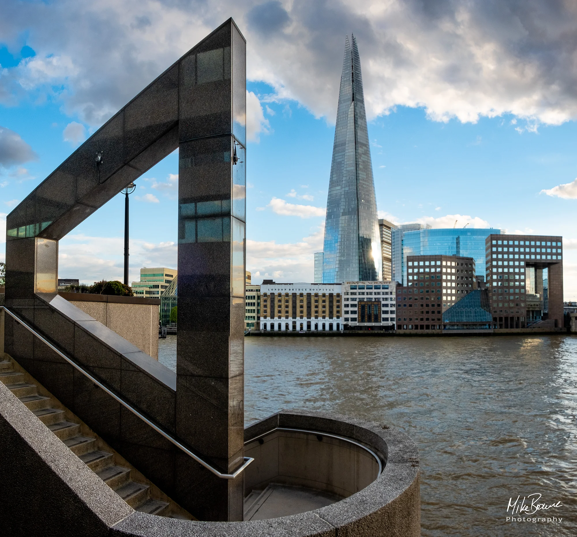 Trapezoid shape on stair rail with The Shard in the background across The Thames