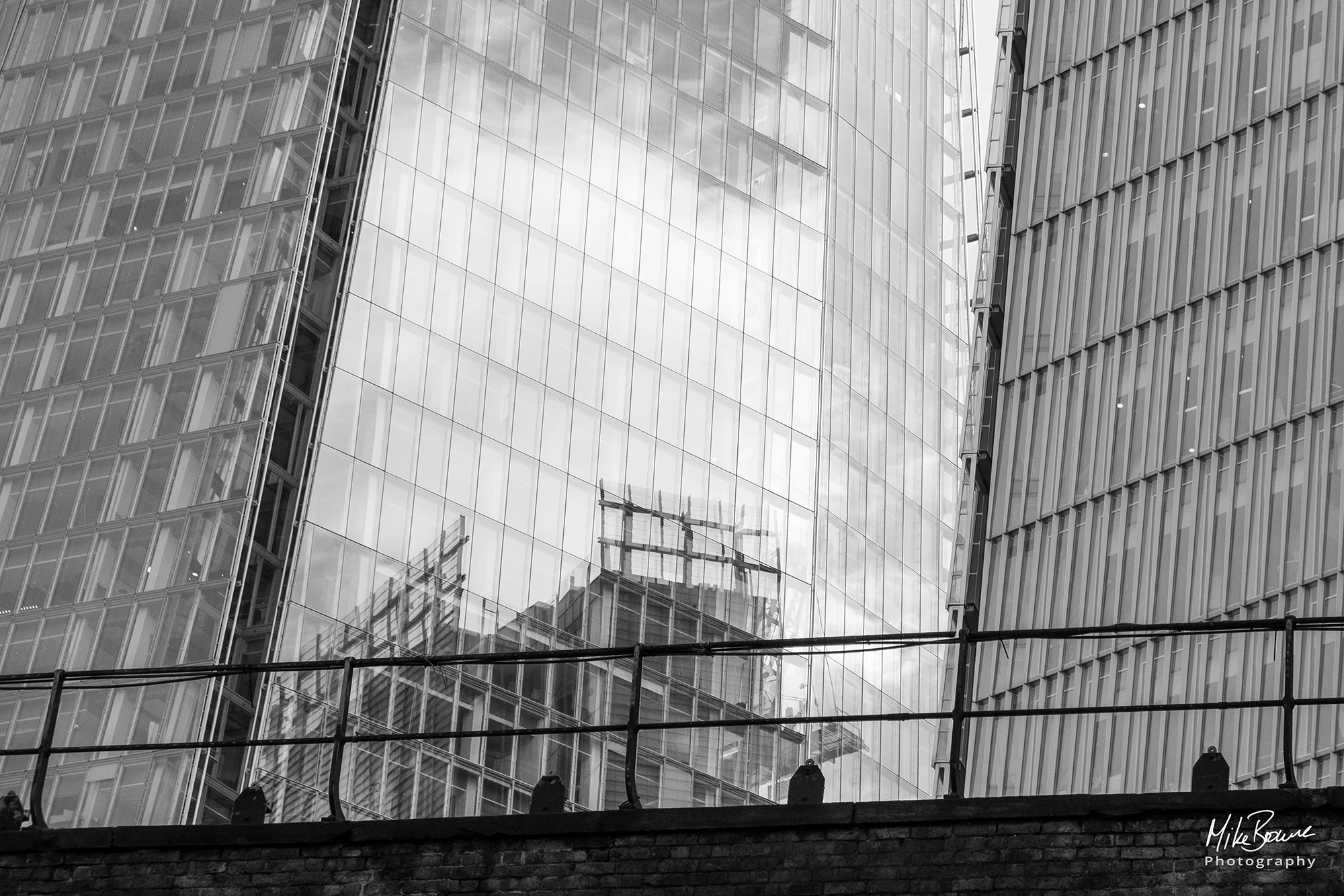 London\'s modern glass fronted buildings behind railings