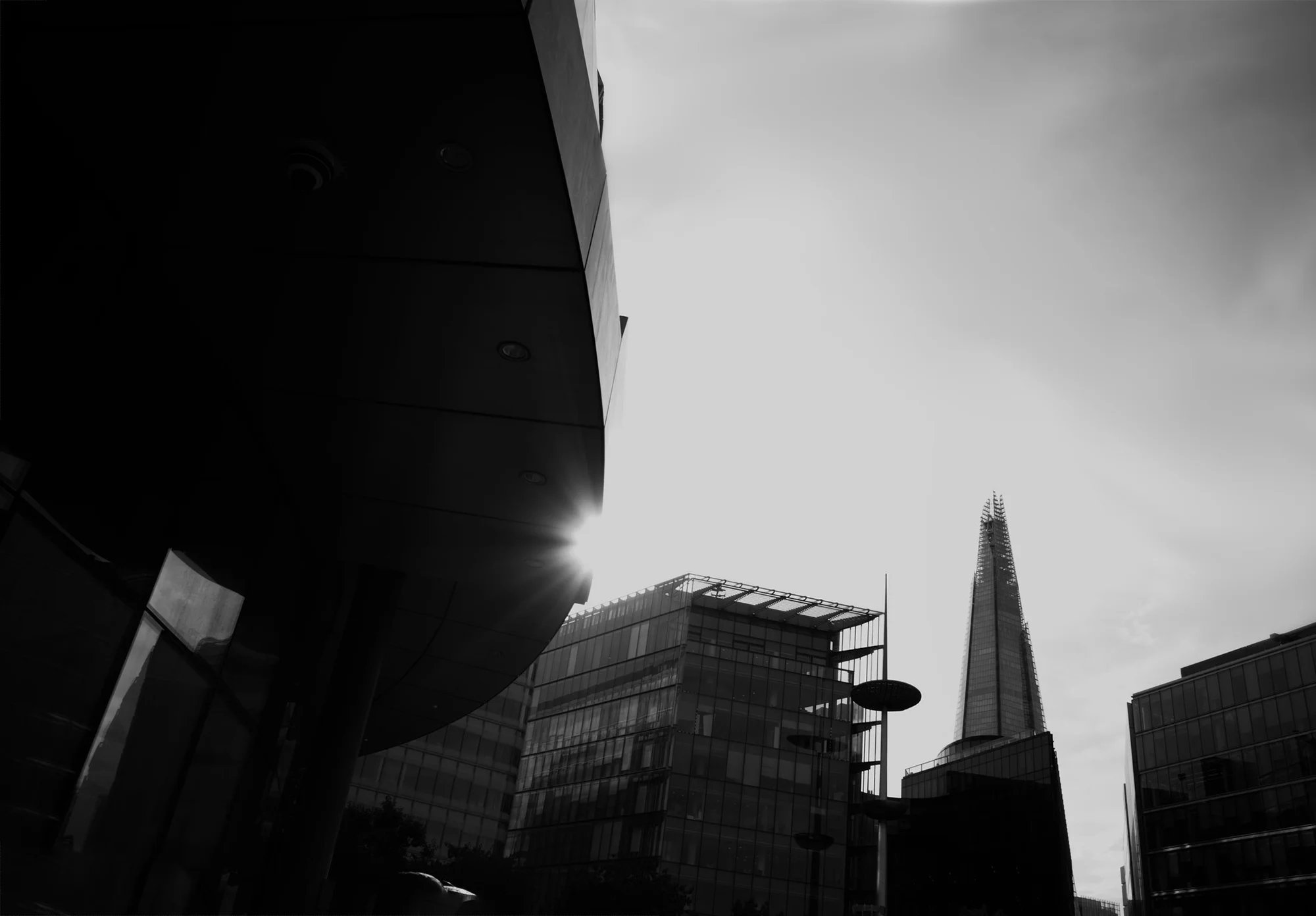 Shapes of London city buildings against the sky with The Shard in the background