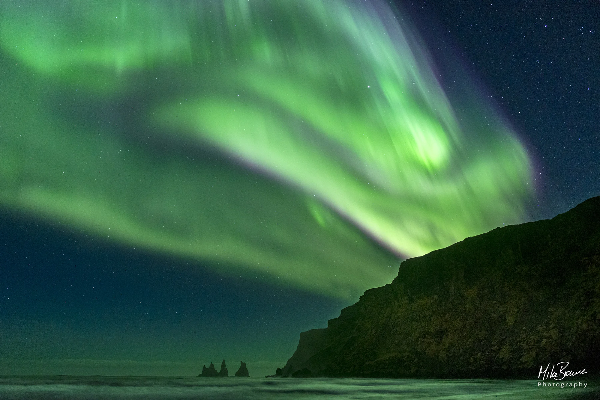 Green northern lights above the sea stacks at Vik Iceland