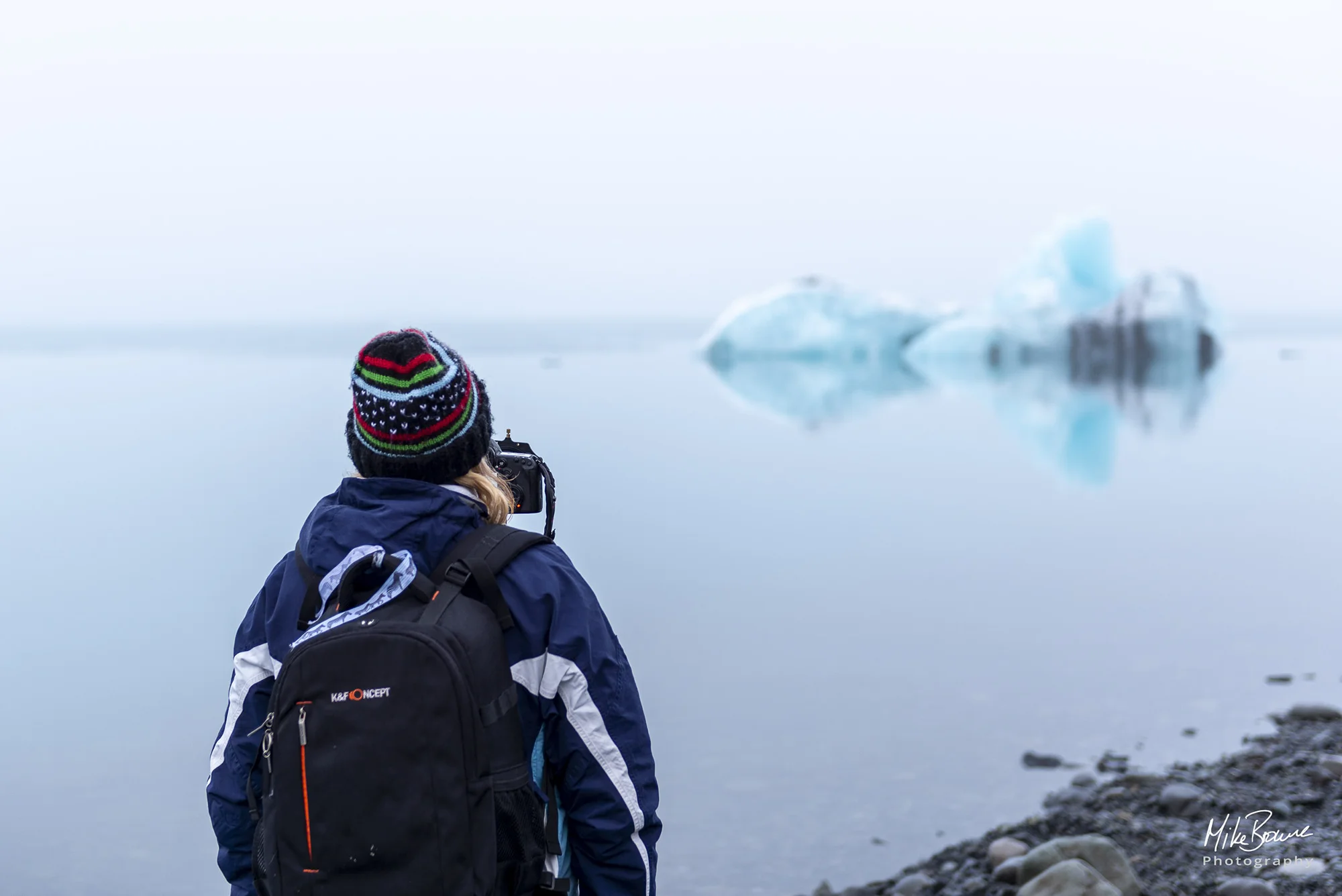 Female photographer photographing an iceberg at glacier lagoon in Iceland