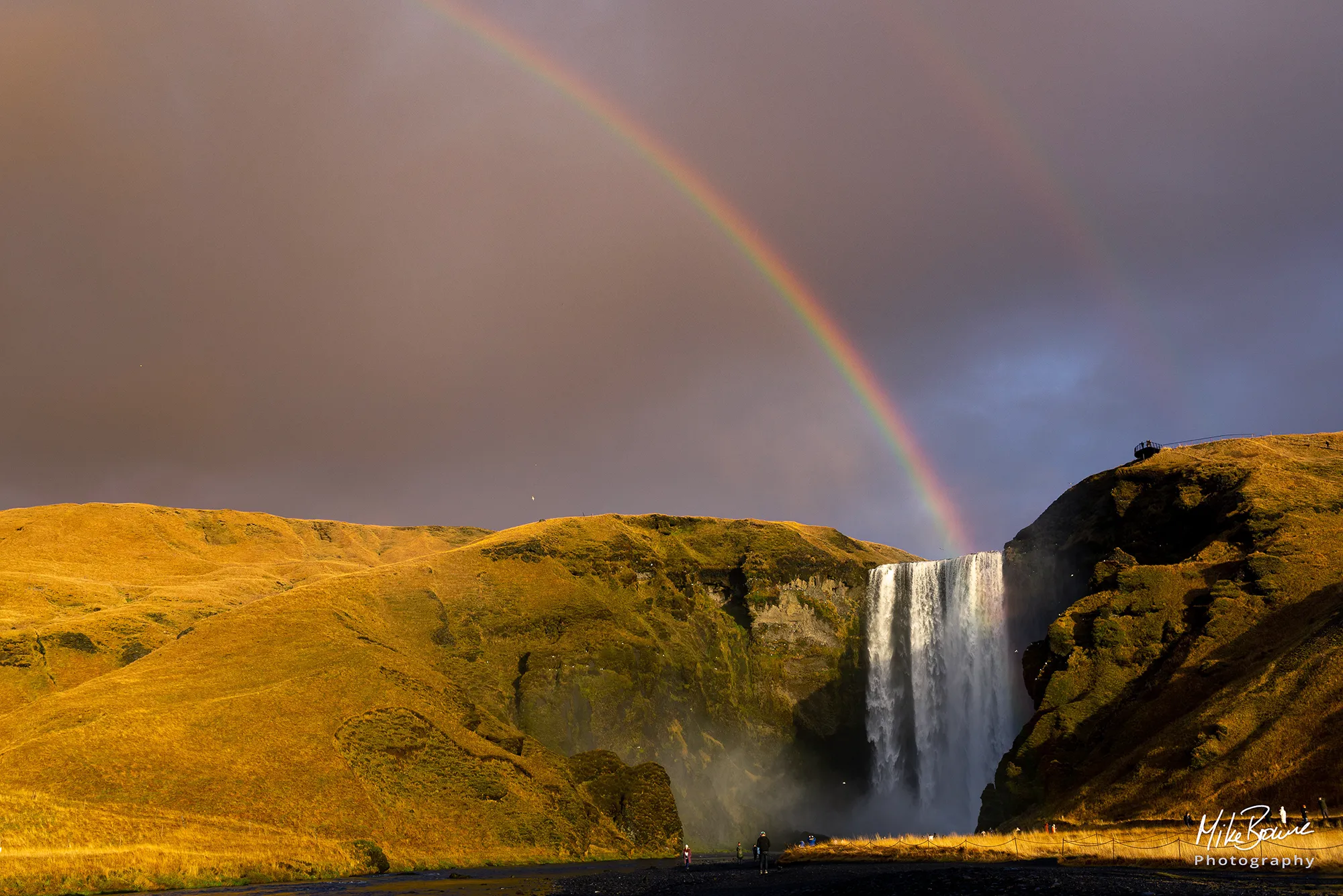 Rain clouds and rainbow over a waterfall