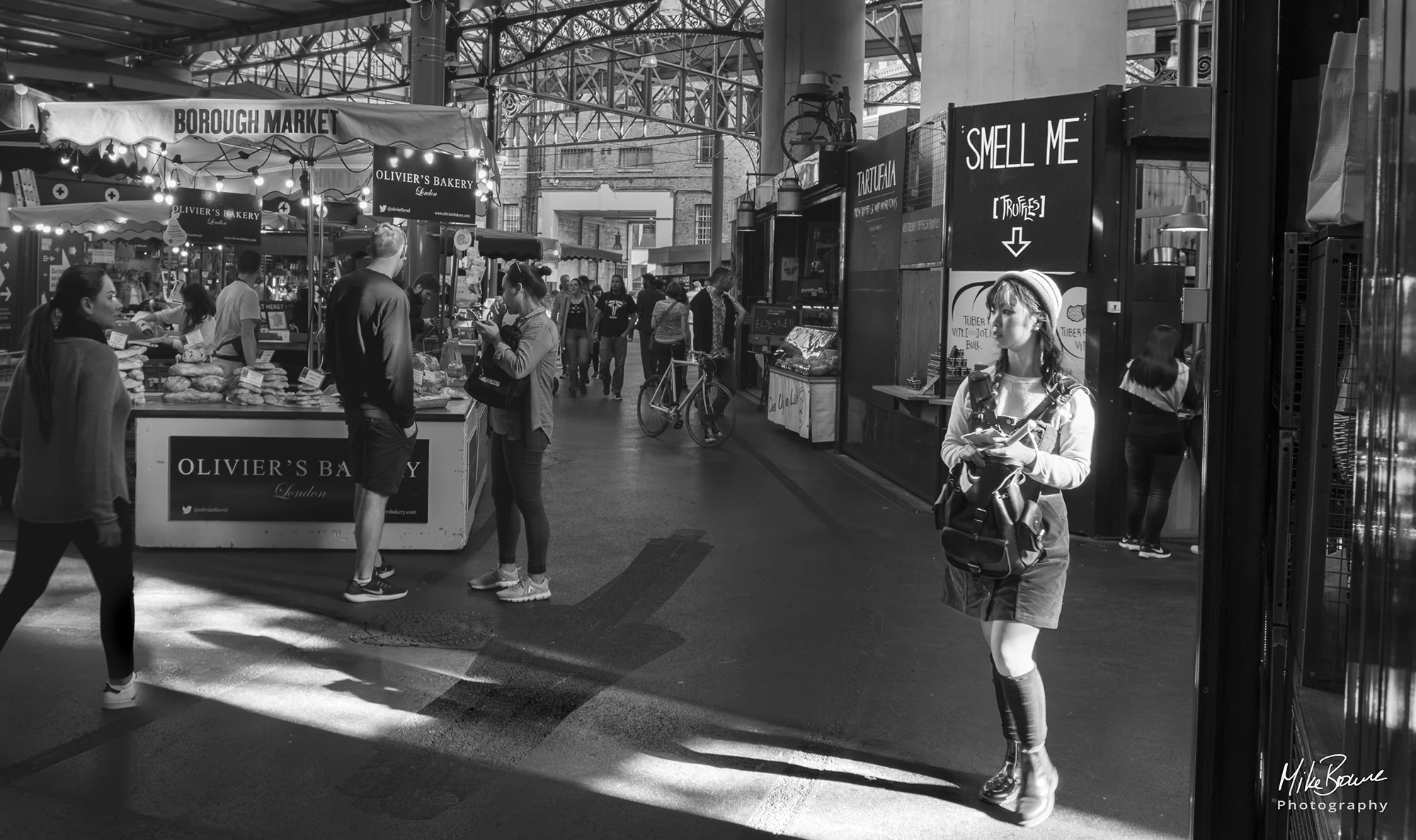 Girl below sign reading smell me in Borough Market, London