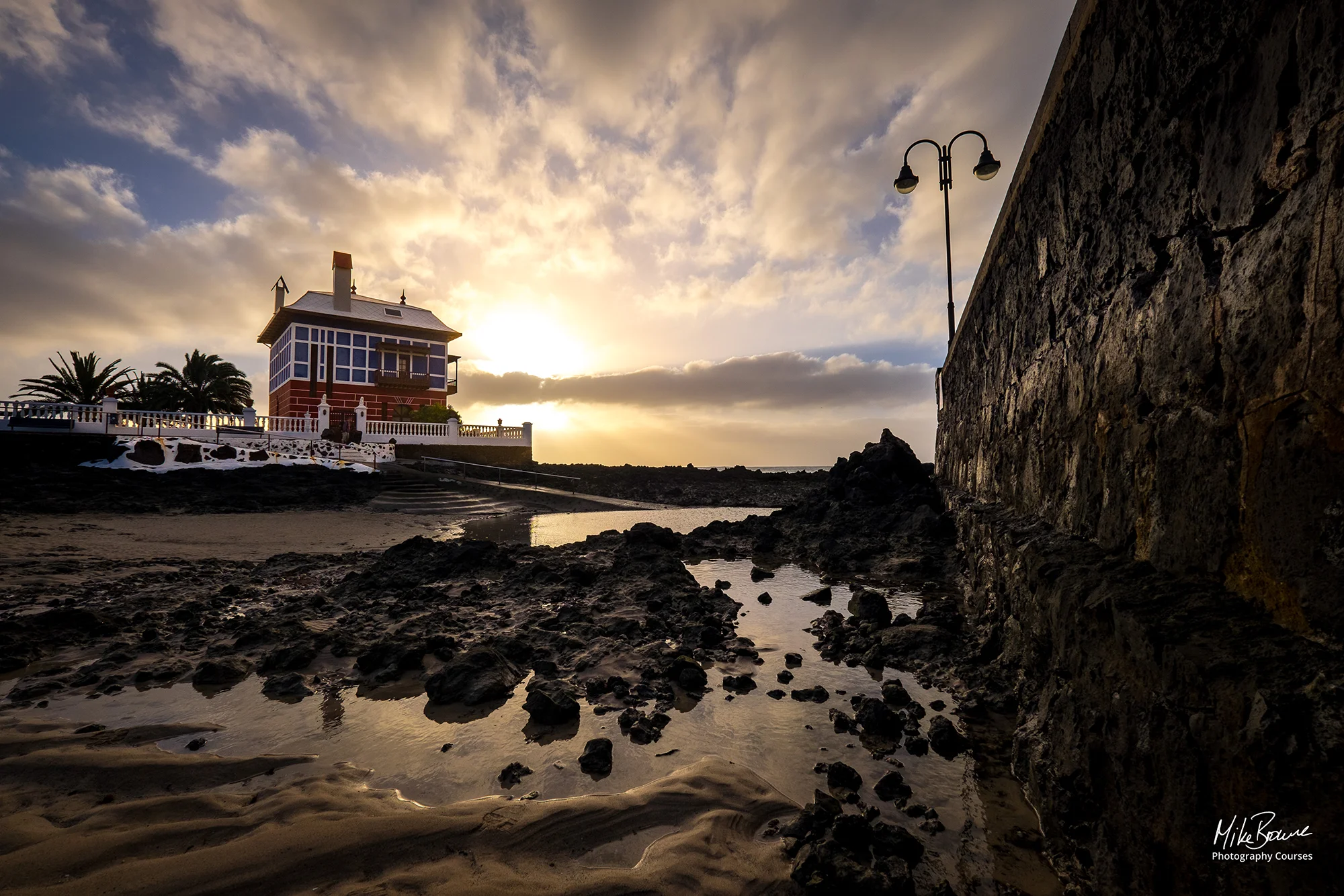 Red house with blue glass by a rock pool in Arieta, Lanzarote