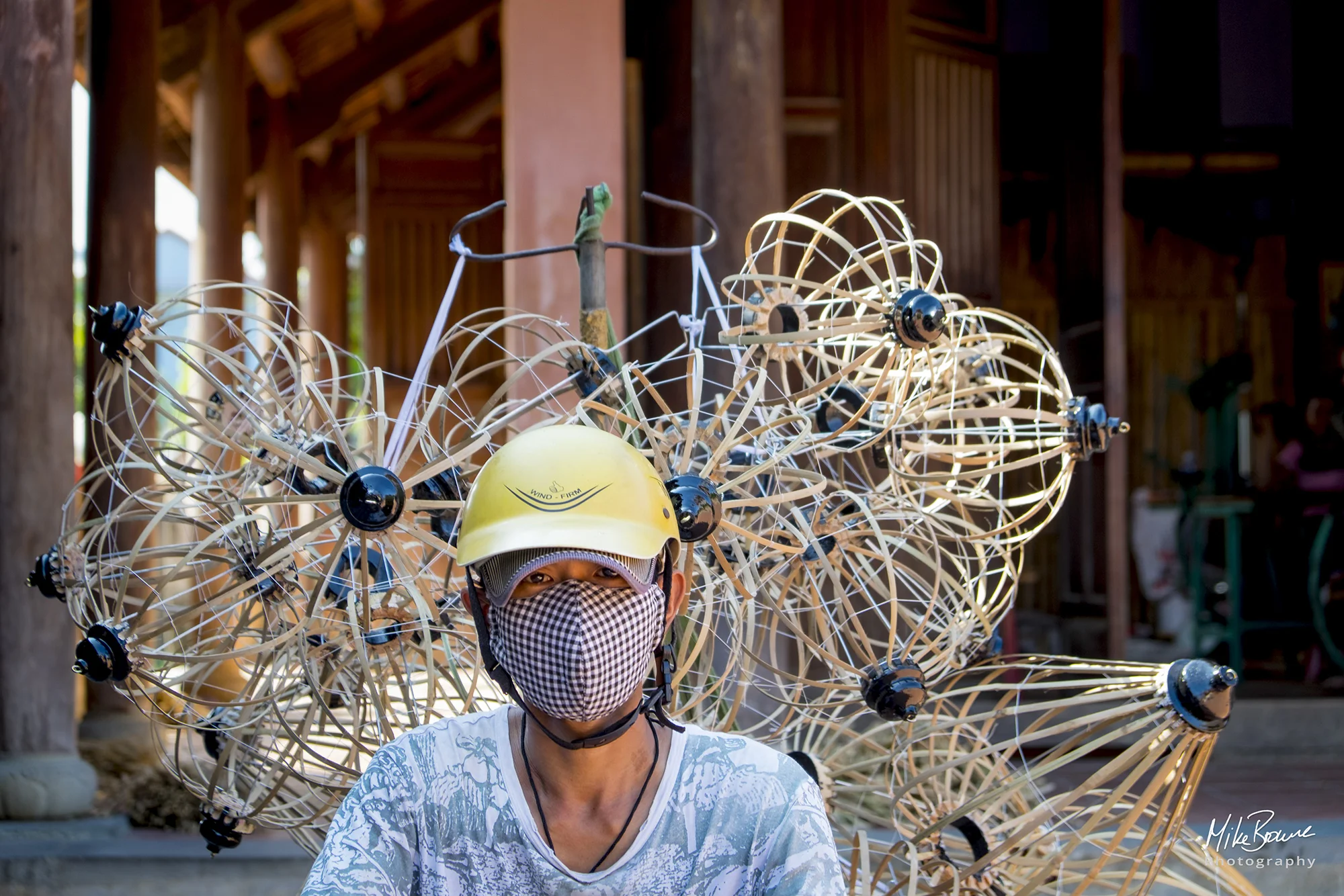 Man wearing yellow helmet and lantern frames on his back