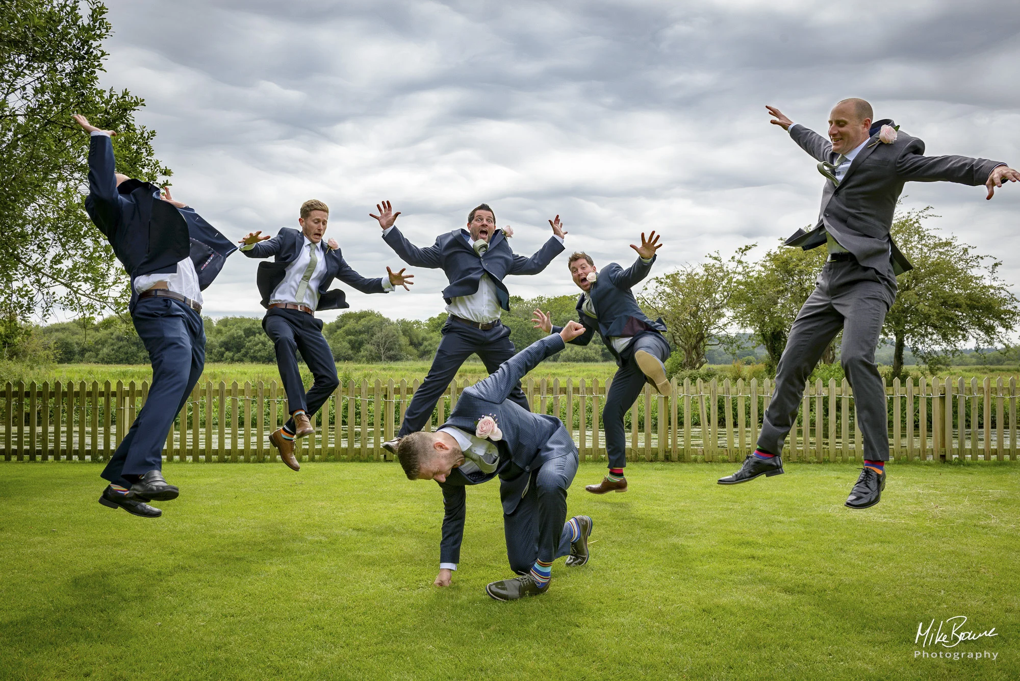 Grooms men leaping into the air at a wedding