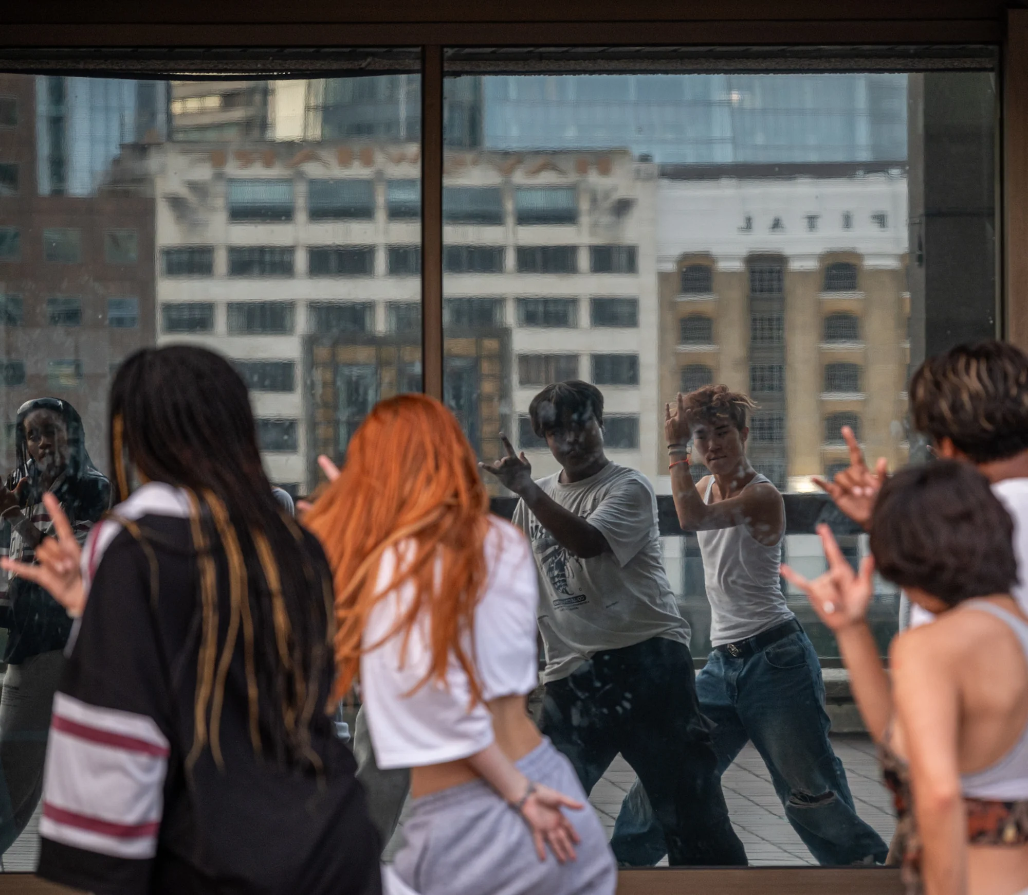 Cool young dancers practicing a routine in an office window