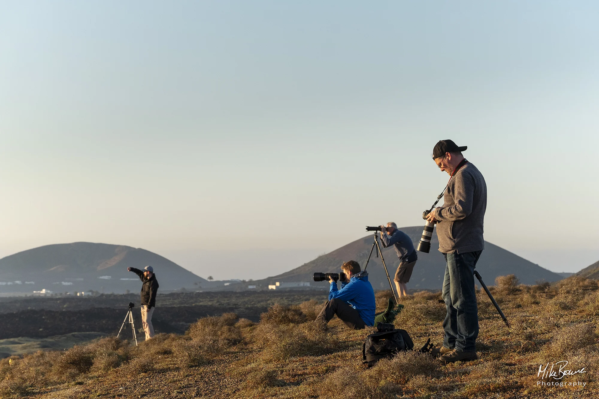 Four photographers with their cameras on a hillside near Cueva de Ortiz, Lanzarote