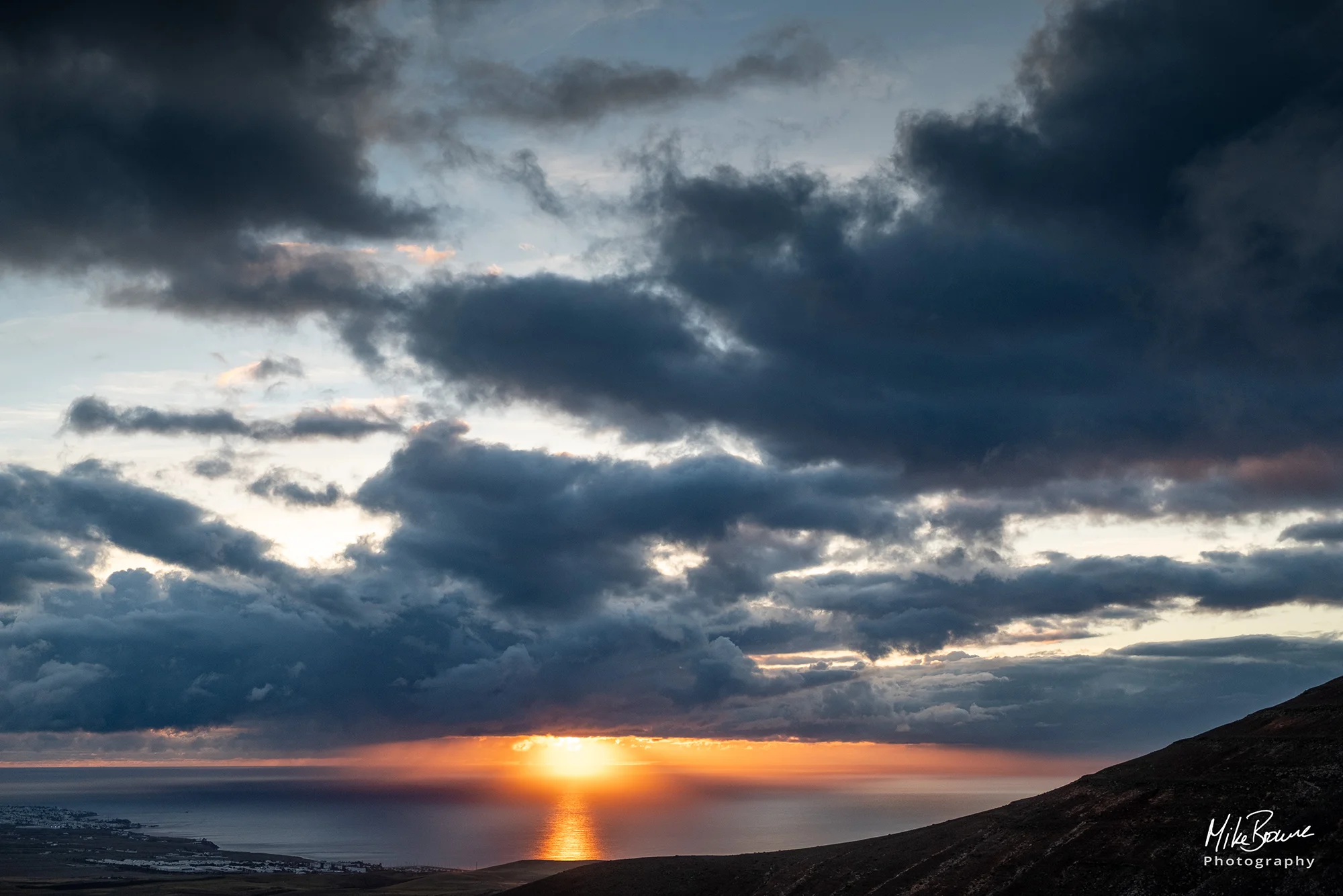 Sunrise and storm clouds over the sea off the coast of Playa Quemada, Lanzarote