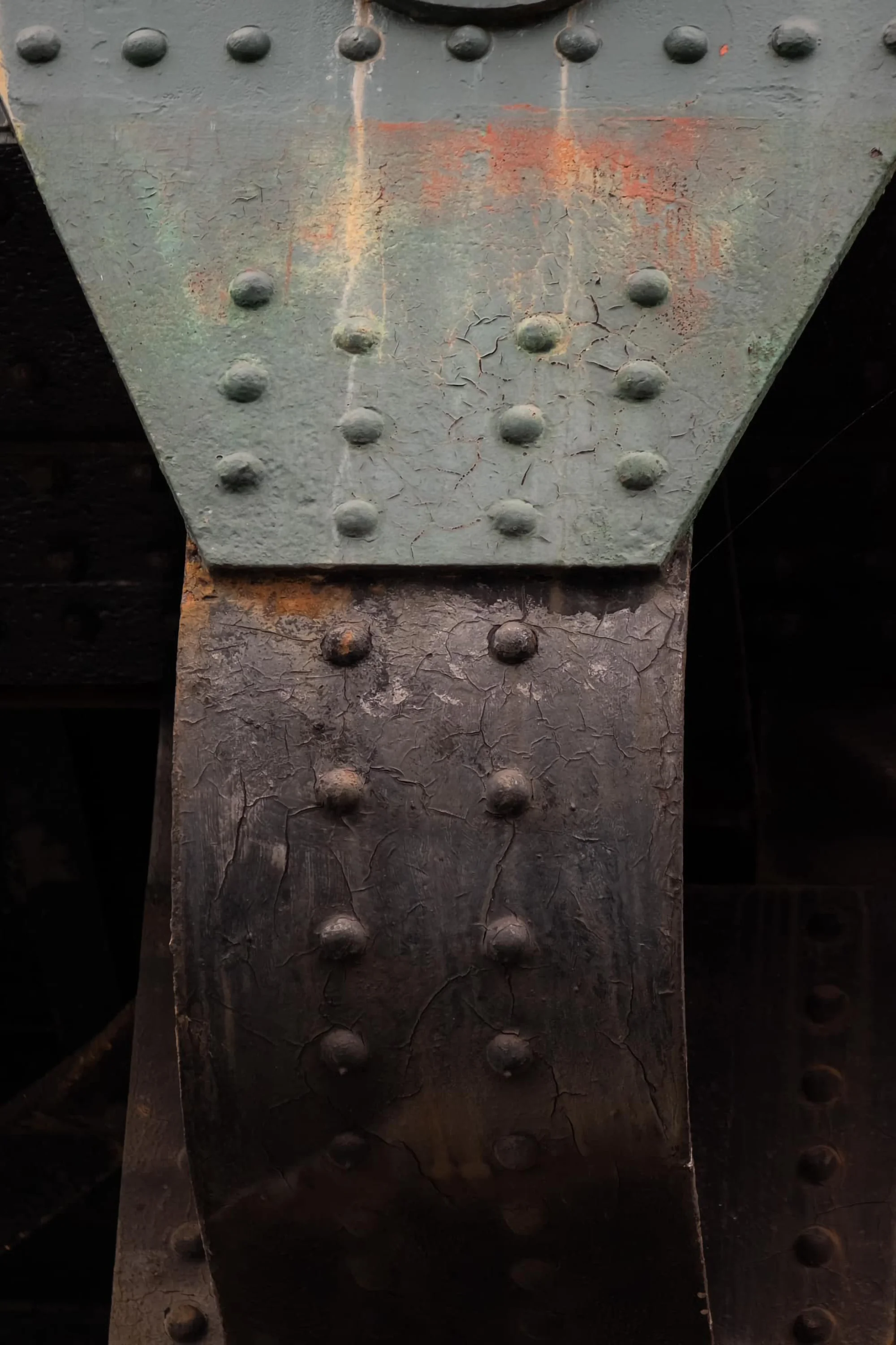 Light playing on abstract shapes of a riveted iron girder on a Bridge over the River Thames in London