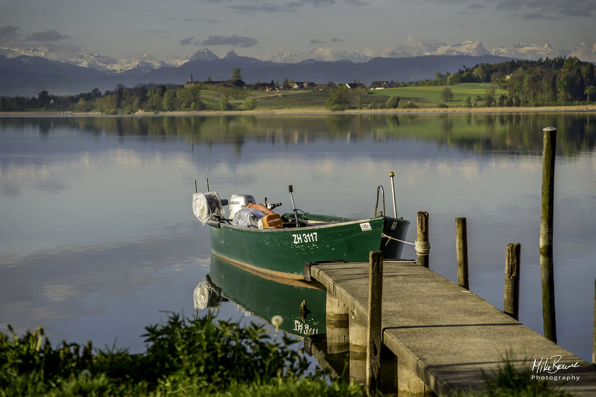 Green boat tied to a dock at lake Pfäffikersee Switzerland