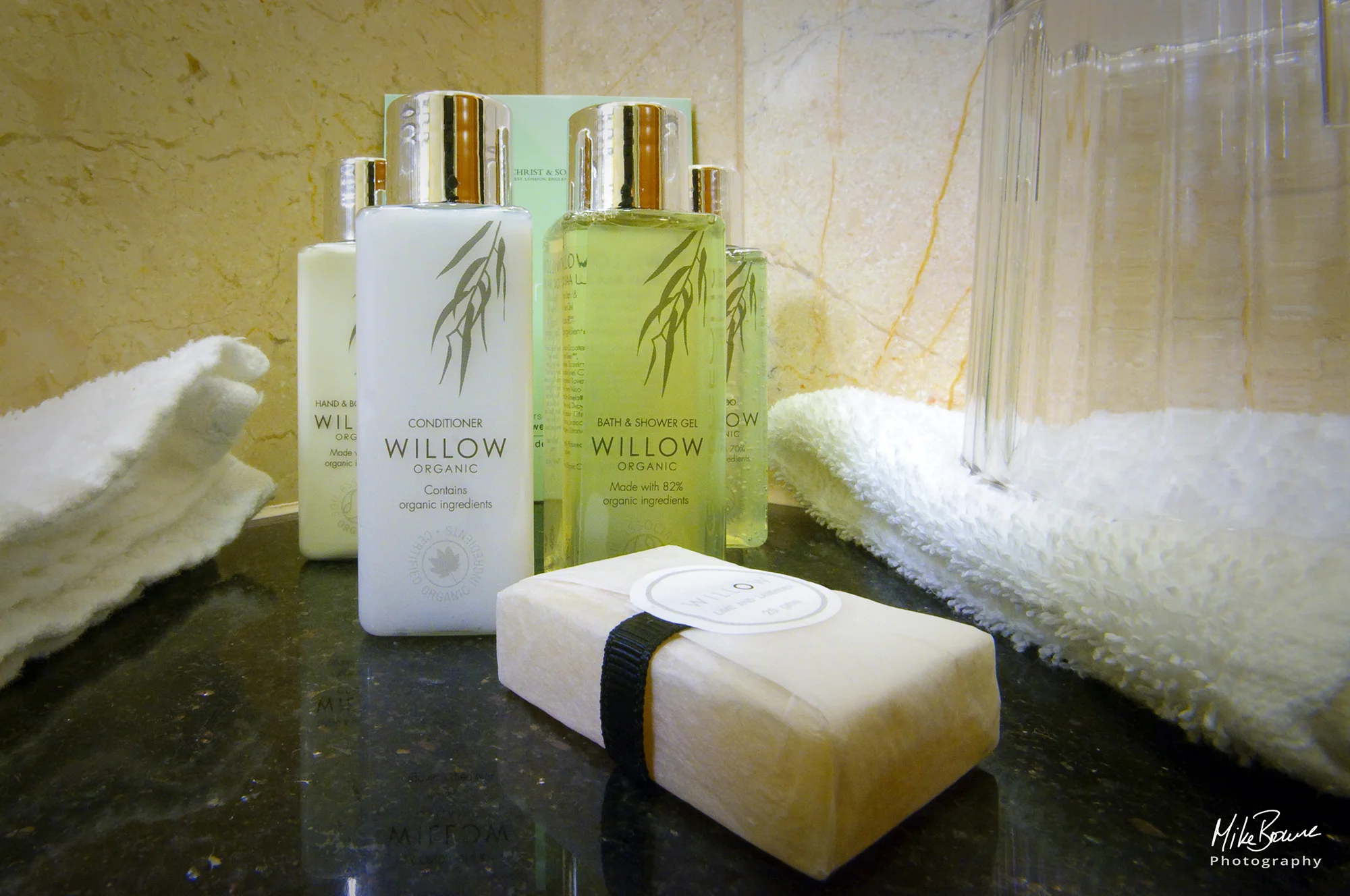 Willow soap bar, shampoo and conditioner with towels on marble stand