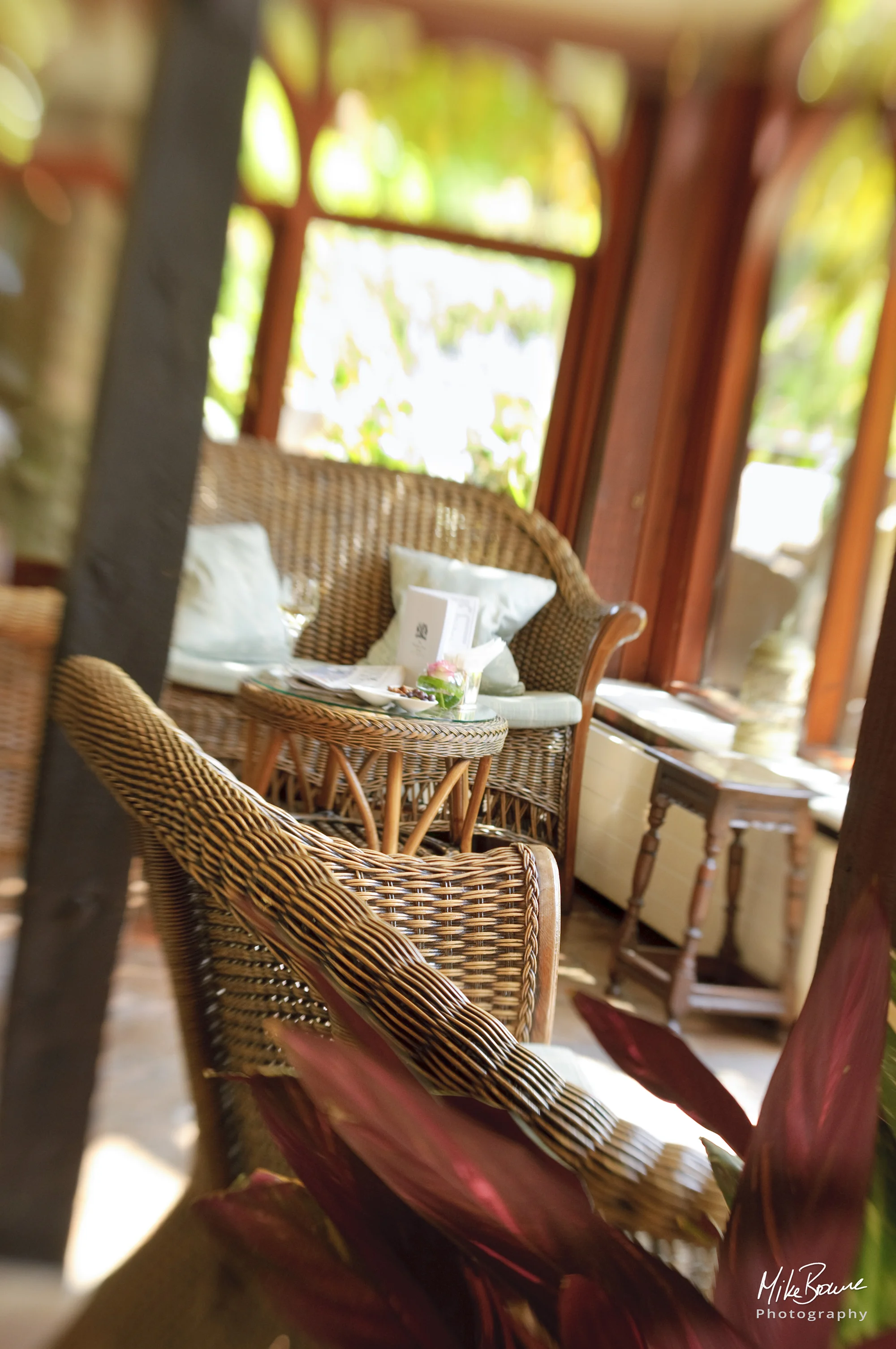 Wicker chairs in a hotel conservatory with glimpse of garden beyond