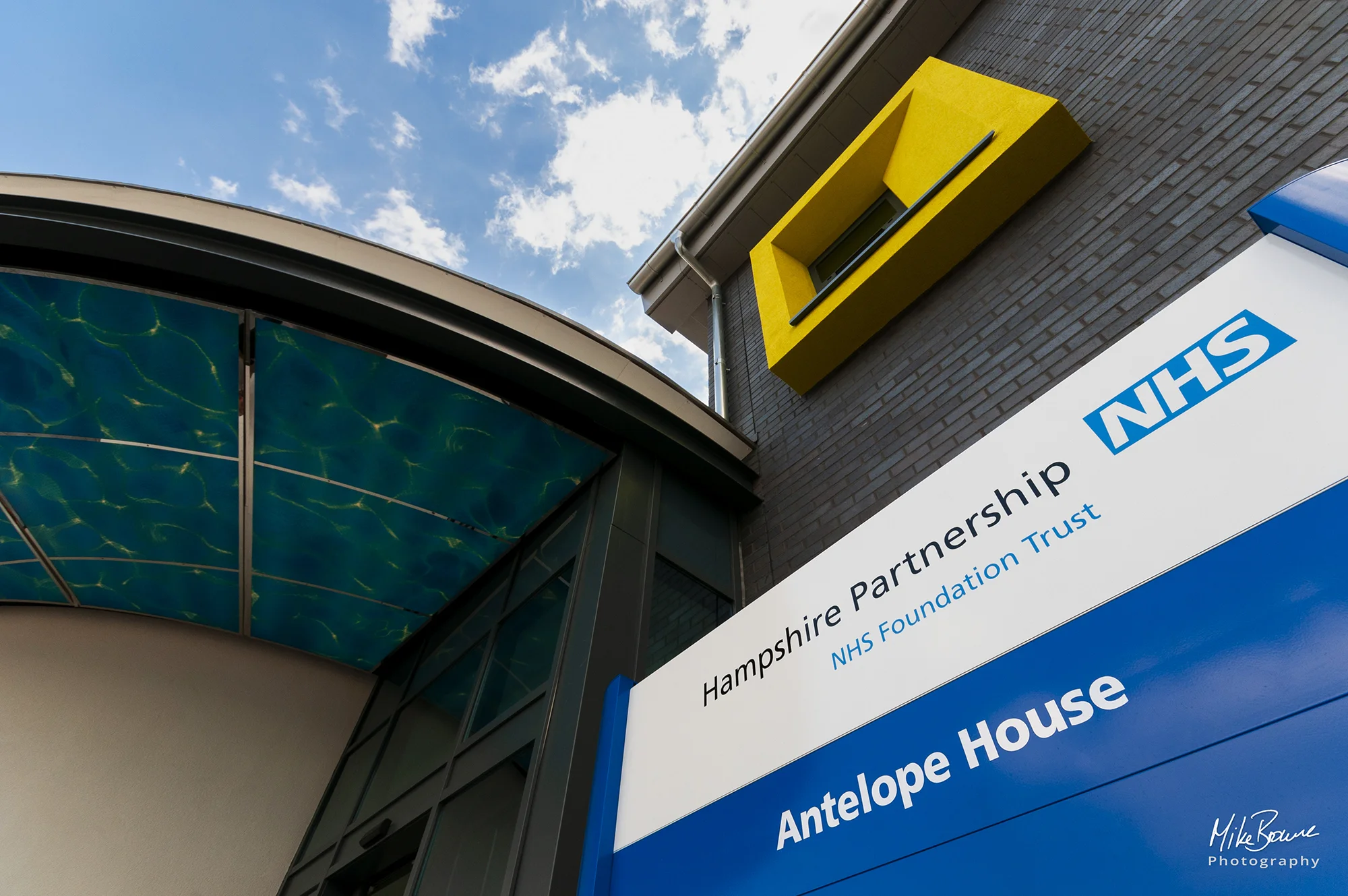 Entrance and NHS Trust Antelope House signage with large modern yellow window in Southampton UK