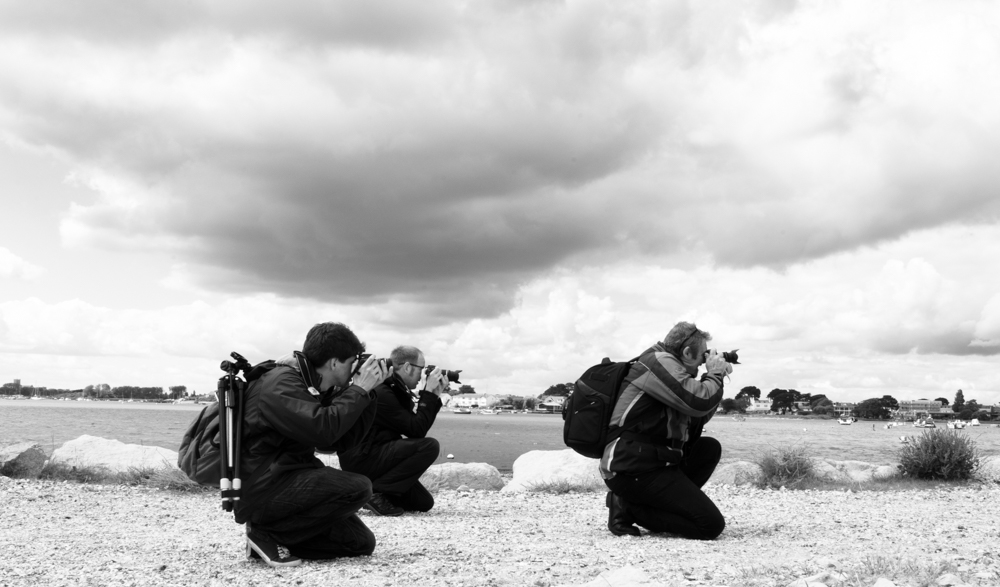 Mike Browne facing the right and kneeling to take a shot with his workshop attendees