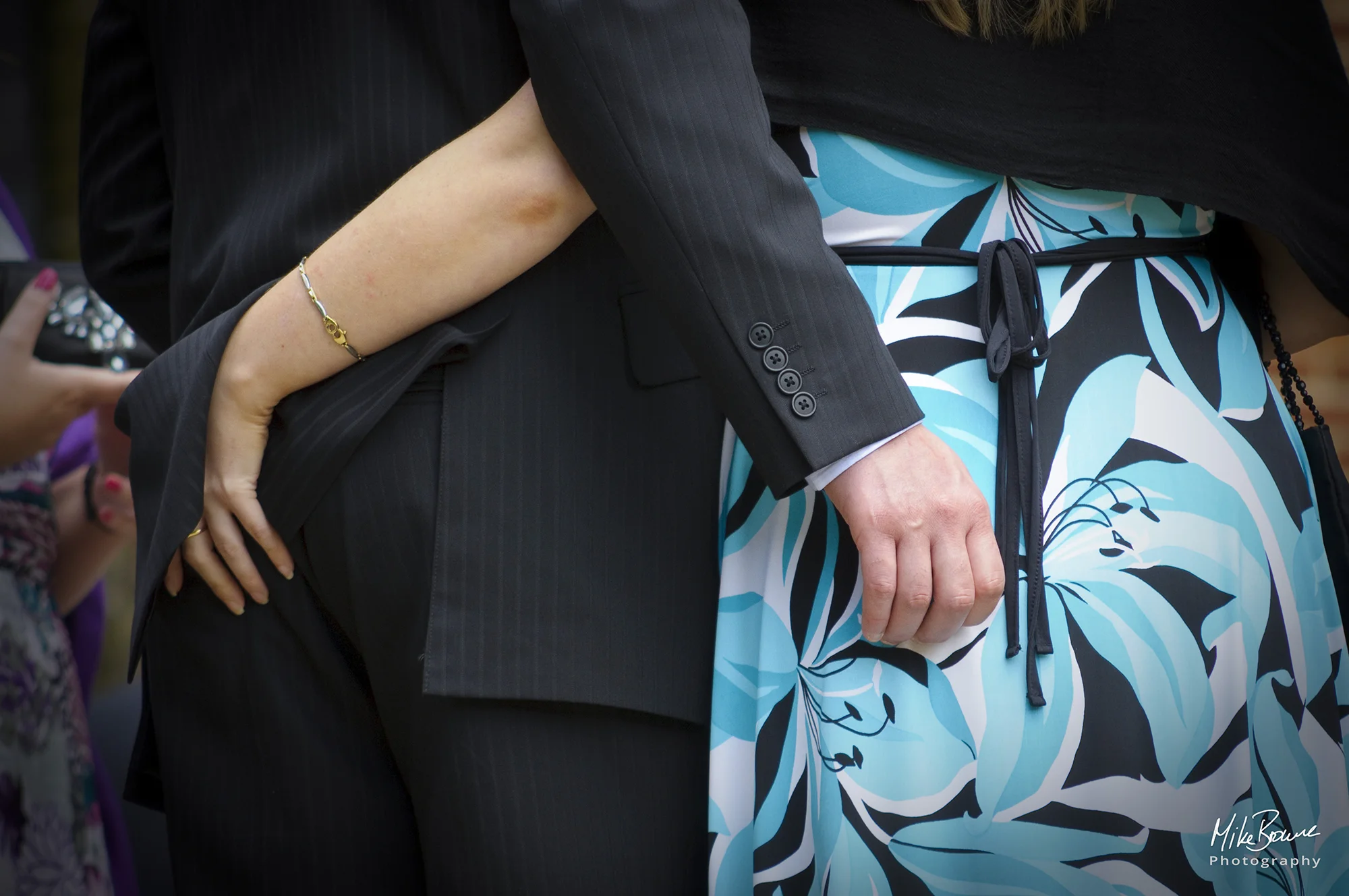 Man and woman with arms round each other hands resting on their bottoms