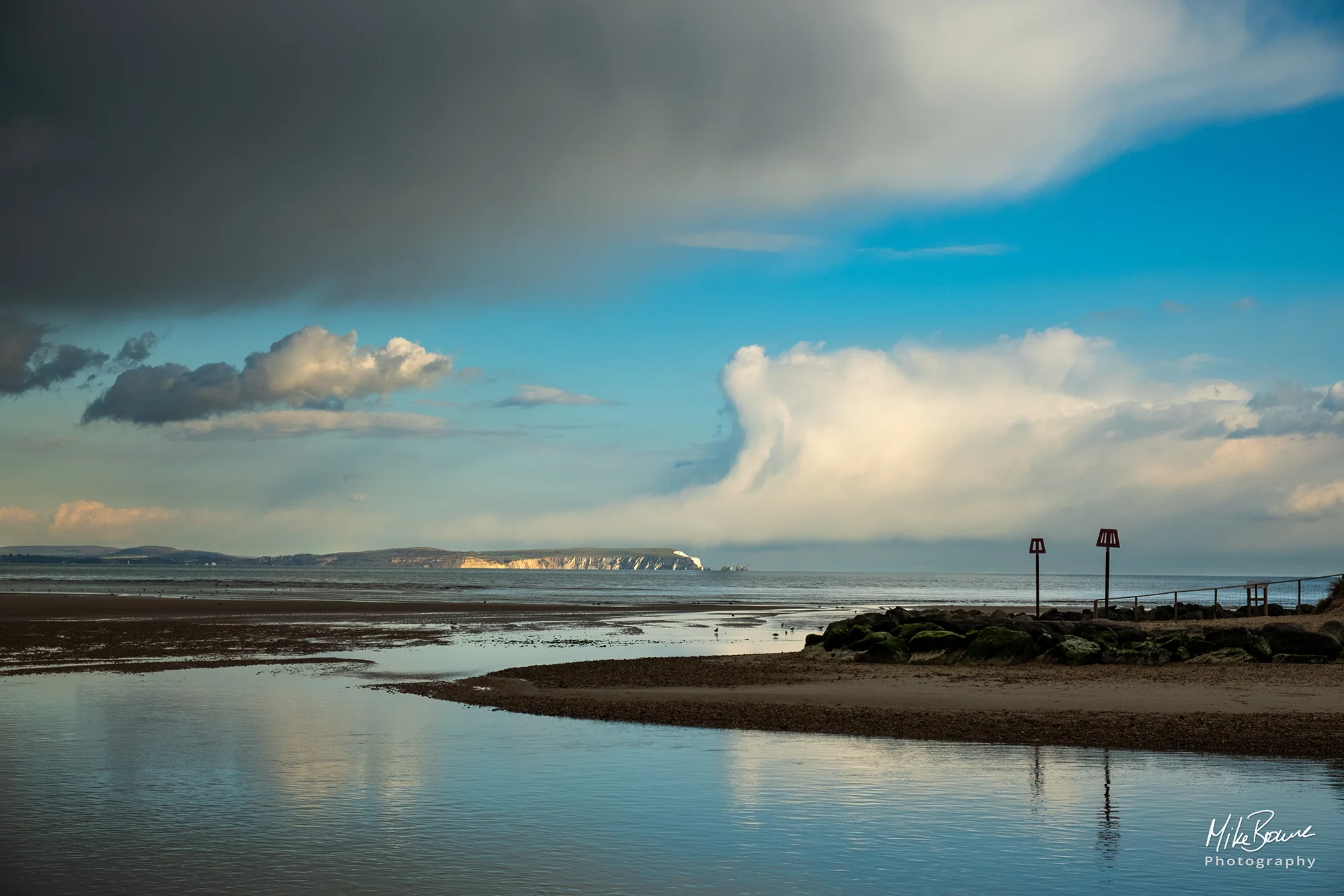Estuary at low tide with Isle of Wight, blue sky and clouds in background