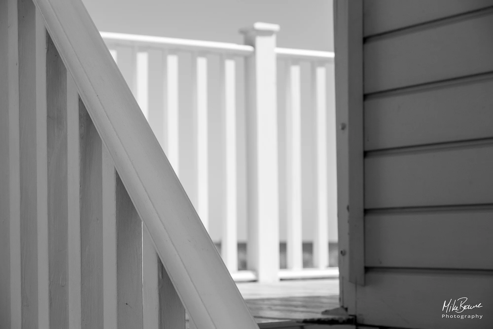 Light on bannister railings on balcony of a beach hut at Hengistbury Head UK