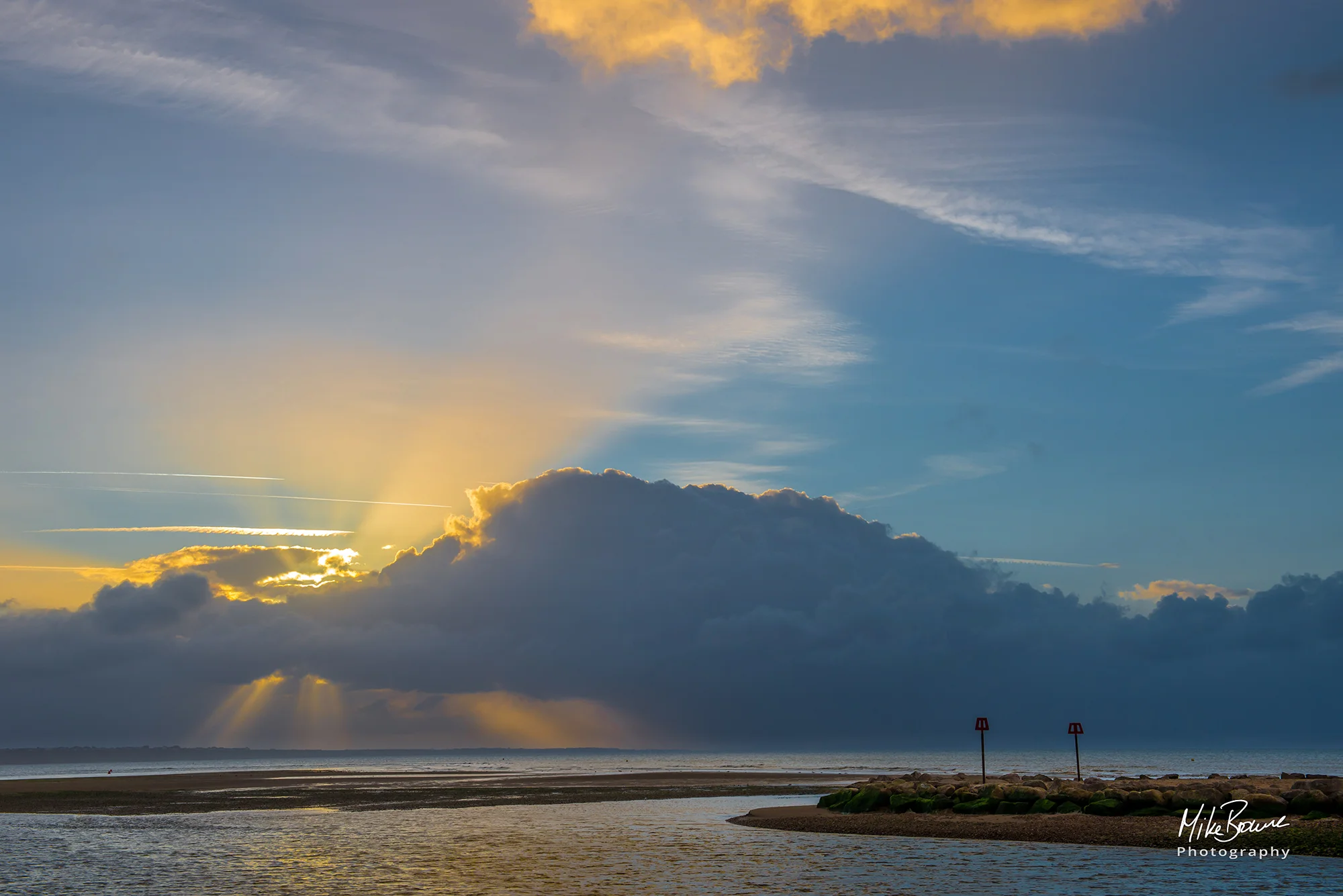 Rays of sunlight coming from behind clouds over the sea