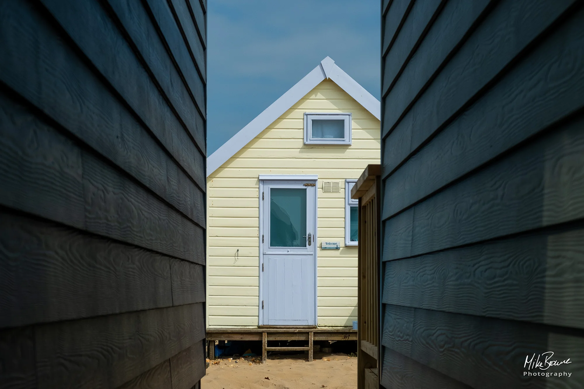 Blue and yellow beach hut at Hengistbury Head, UK