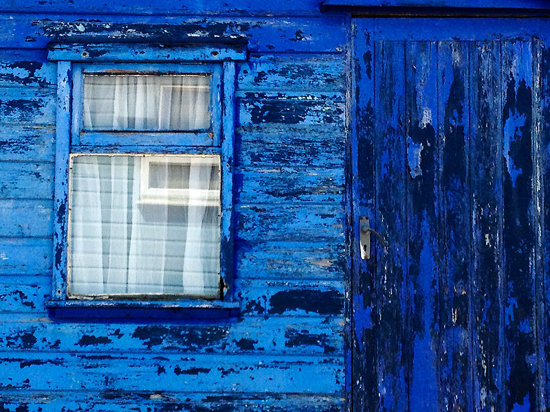 Window frame of weathered blue beach hut