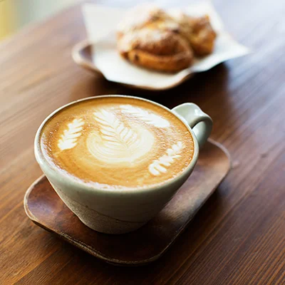 a cup of black coffee being held by it's handle