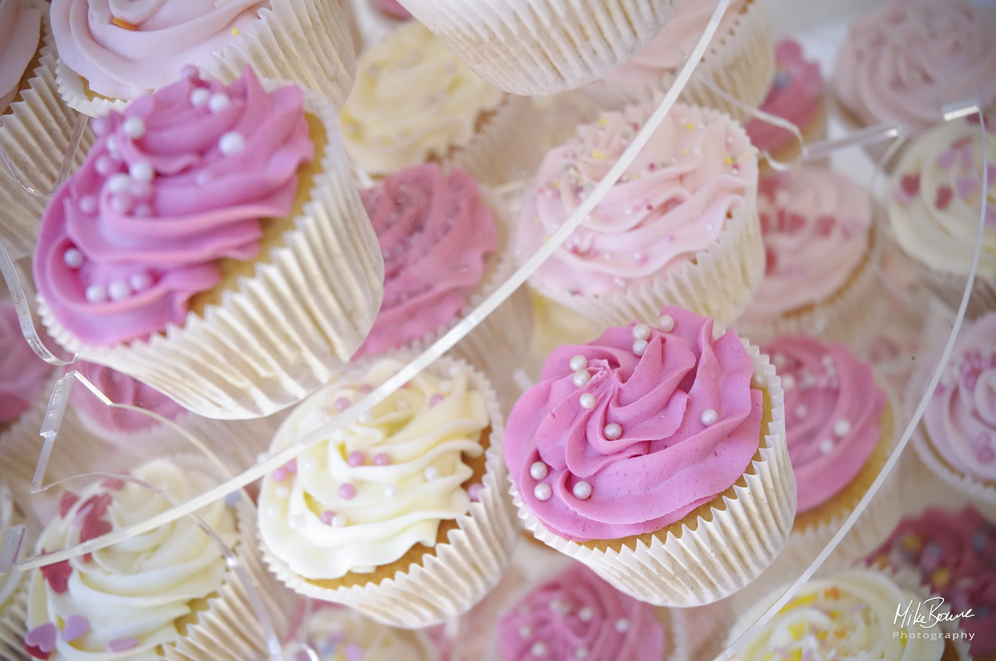 pink and yellow iced cup cakes decorated with silver sugar balls