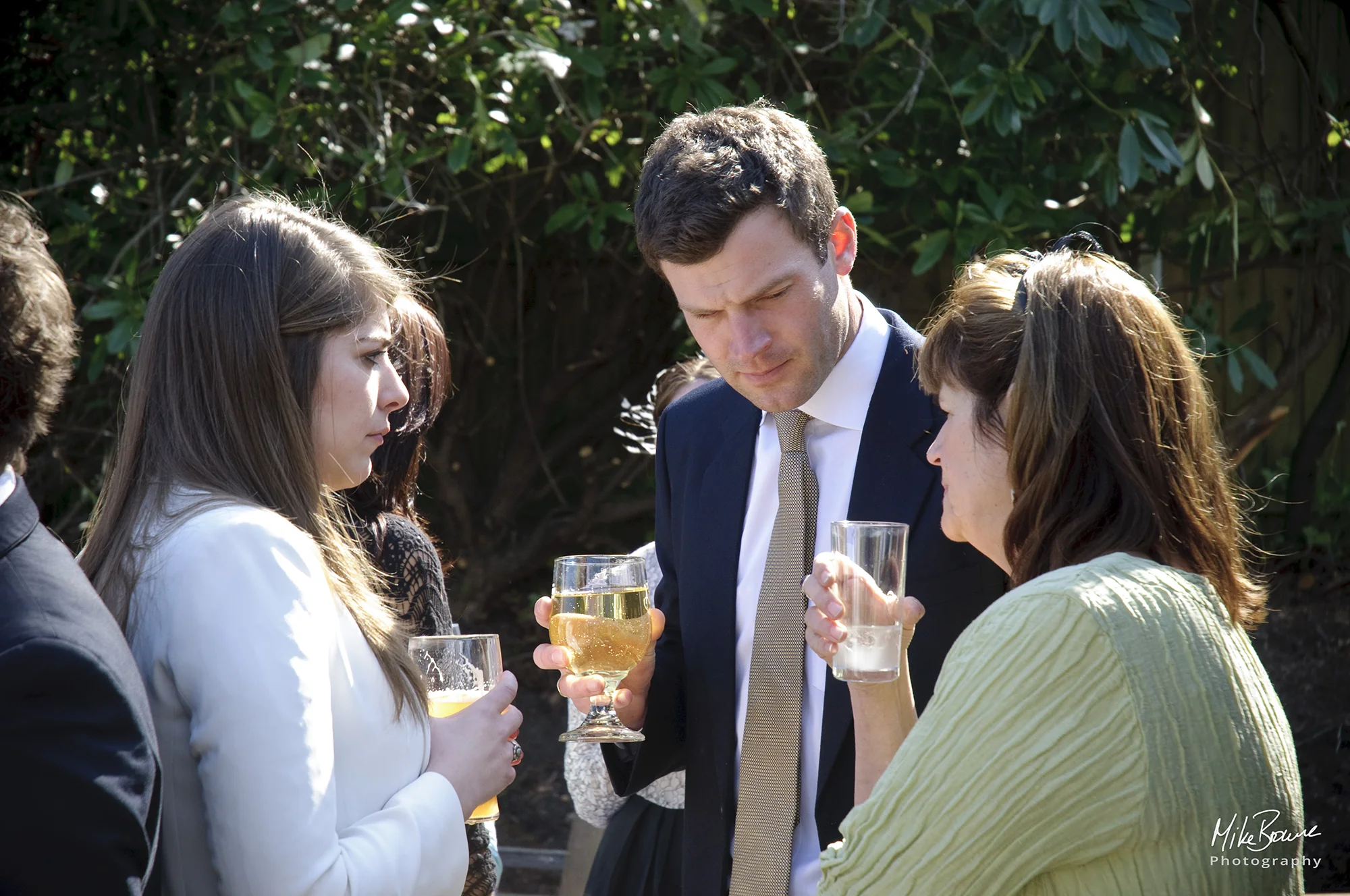 group of three people with serious expressions and drinks in their hands