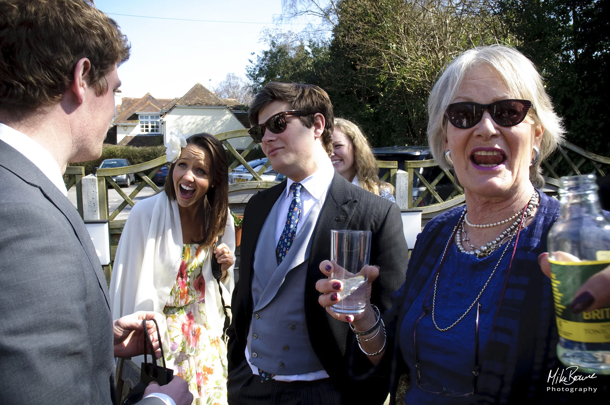 Guests at a pre wedding drinks party laughing whilst in conversation