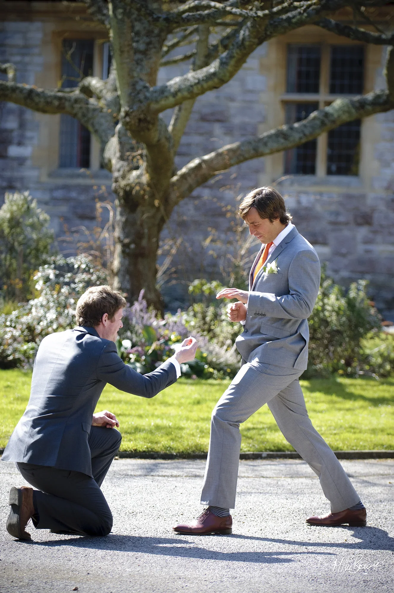 Best man pretends to propose to the groom in front of a church