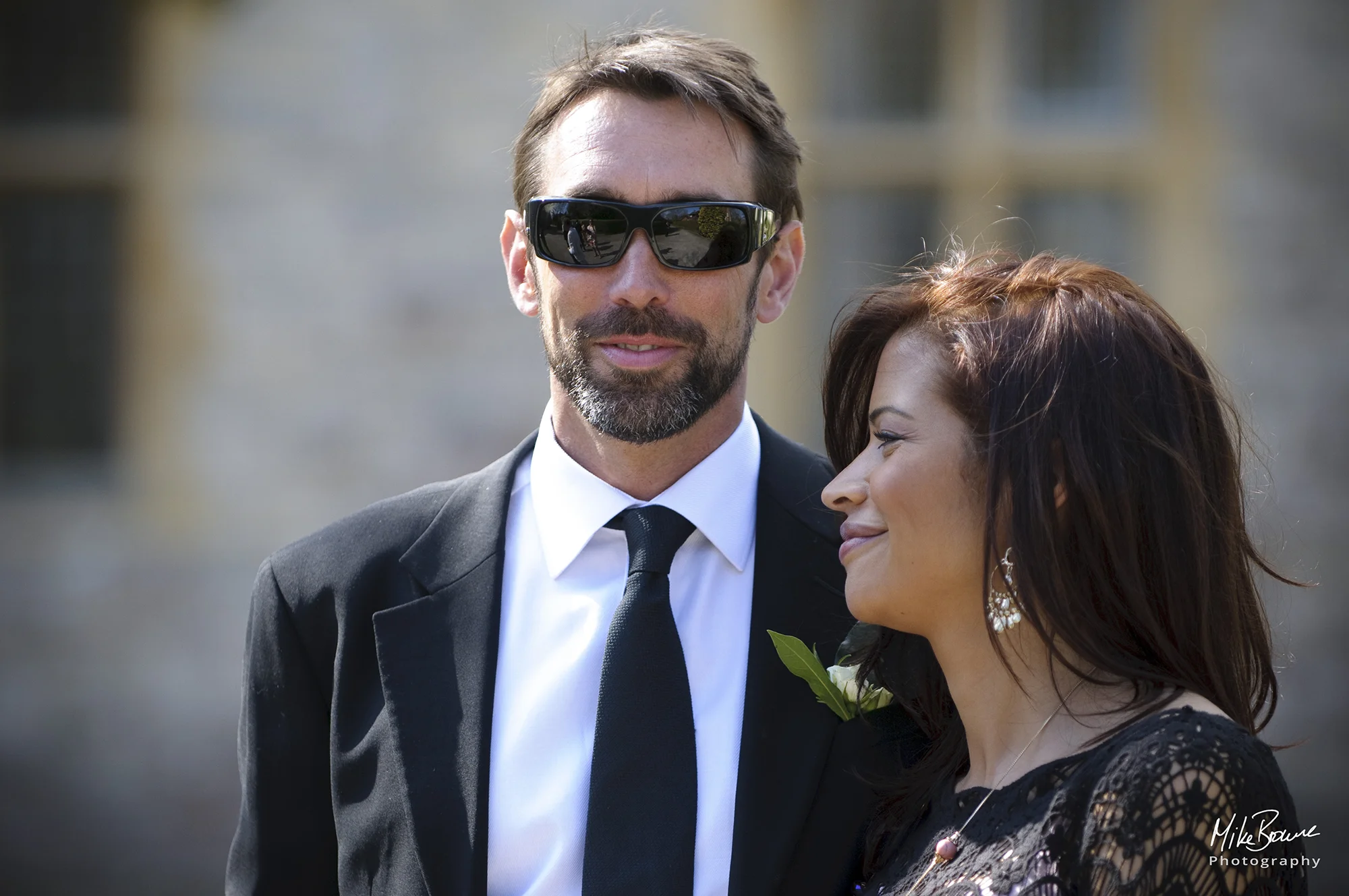 A man and woman dressed for a summer wedding