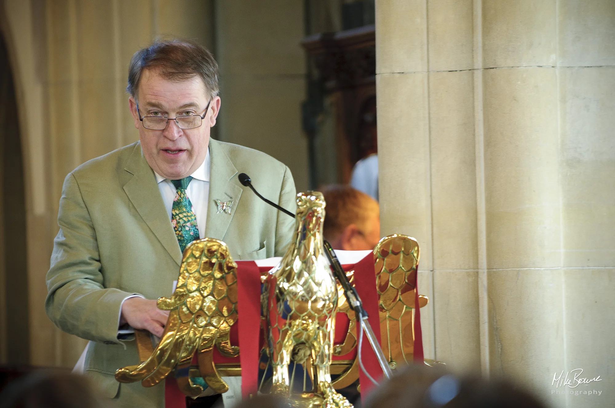 Man in glasses speaks to the congregation from the church lectern