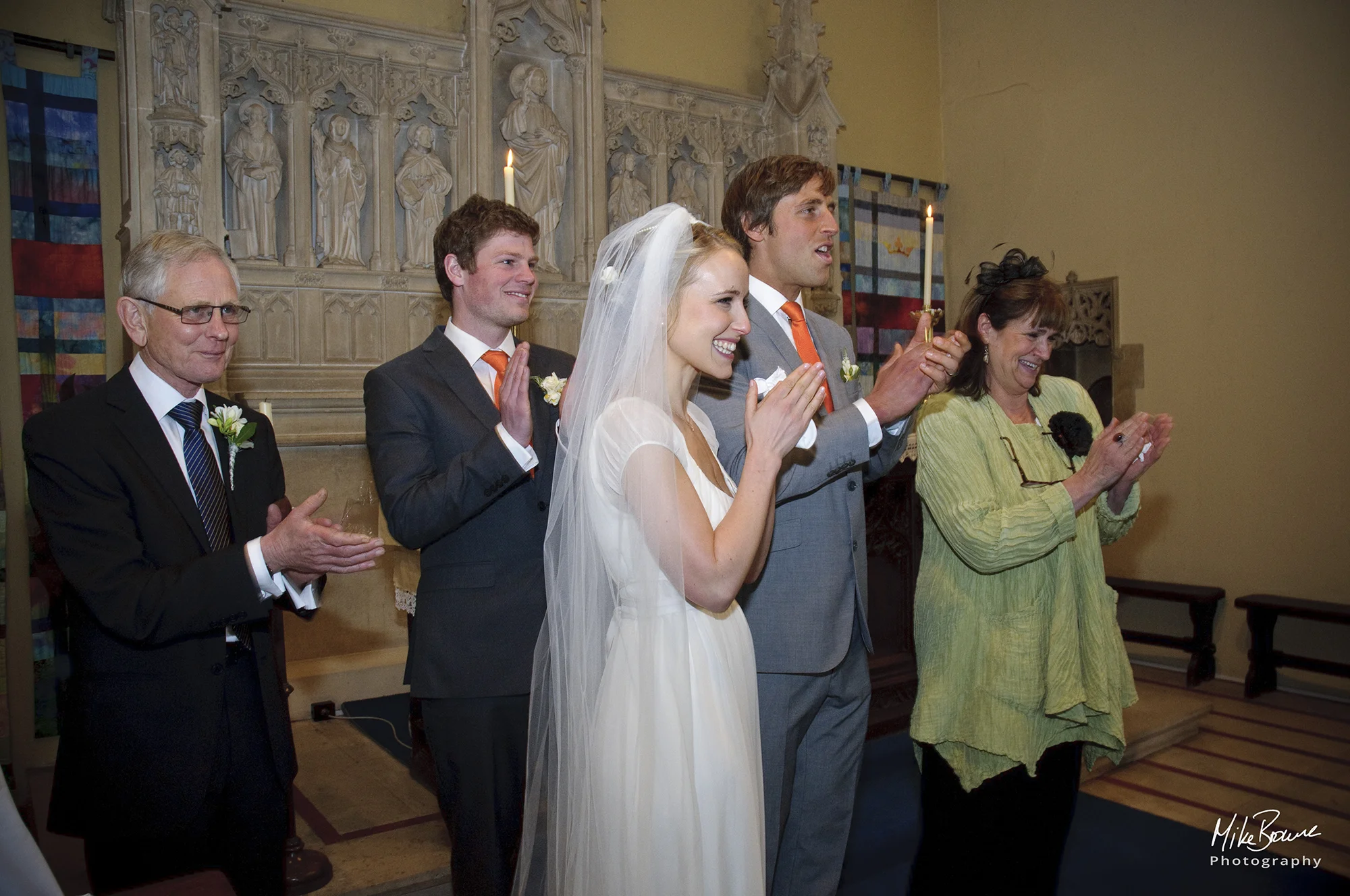 Newly married couple clap to applaud a friend who sang at their wedding